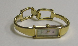 A lady's wristwatch contained in a gilt metal case by Gucci, the reverse marked 1500