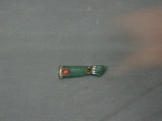 A jade coloured hardstone pendant in the form of a fist set hardstones