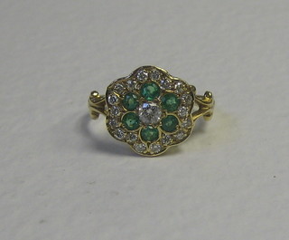 A lady's 15ct gold dress ring set 6 emeralds supported by numerous diamonds