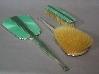 An Art Deco 3 piece silver and green enamelled back dressing table set, with hand mirror, hair brush and clothes brush, Birmingham 1938