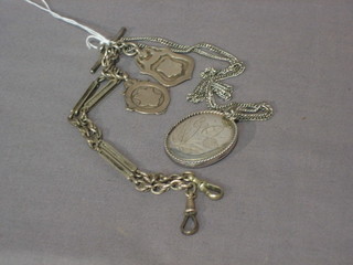 A silver curb link watch chain hung 2 medallions and a silver chain hung a silver locket