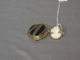 An oval shell carved cameo portrait brooch contained in gilt metal mounts and an oval black striped onyx brooch in gilt metal mounts
