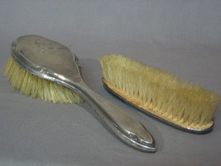 A silver backed hand mirror and a silver backed clothes brush