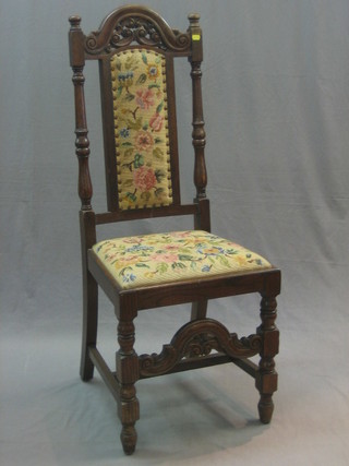 A Victorian Carolean style high back hall chair with pierced and carved cresting rail, the seat and back upholstered in Berlin wool work raised on turned and block supports