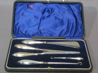 A 4 piece silver backed shoe set comprising glove stretchers, shoe horn and 2 button hooks, cased