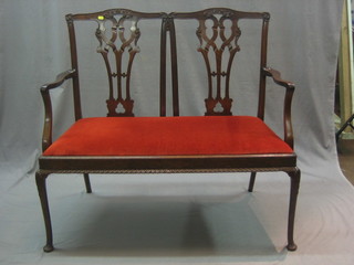 An Edwardian Chippendale style double chair back settee with pierced vase shaped splat back and upholstered drop in seat, raised on cabriole ball and claw supports 41"