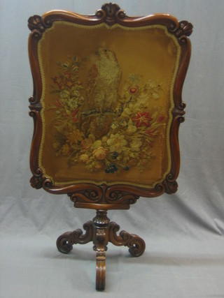 A Victorian carved mahogany fire screen with tapestry panel, raised on a tripod base 28"