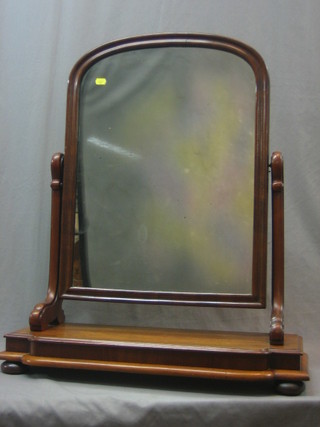A Victorian arched plate dressing table mirror contained in a mahogany swing frame, raised on bun feet 36"