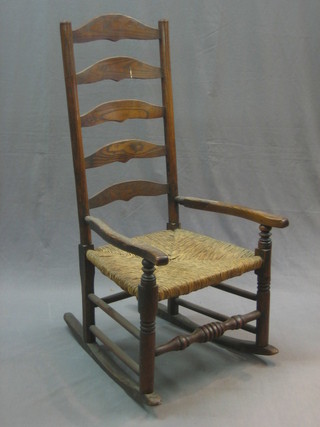 An elm ladder back rocking  chair with woven rush seat (old repair to arm)