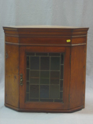 An Edwardian walnut hanging corner cabinet, the interior fitted a shelf enclosed by a glazed panelled door 24"