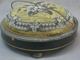 A Victorian circular ebonised footstool with gilt bead work border and upholstered seat 12"