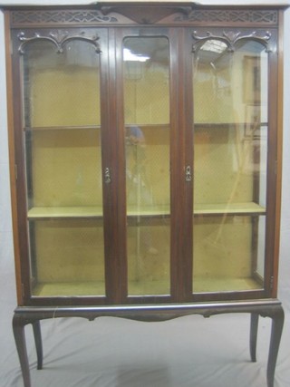 An Edwardian carved mahogany display cabinet the interior fitted adjustable shelves enclosed by glazed panelled doors, raised on cabriole supports 42"