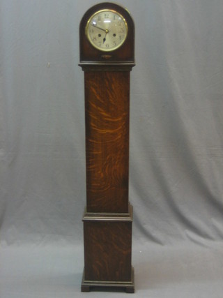 A Granddaughter clock with silvered dial and Arabic numerals contained in an oak case