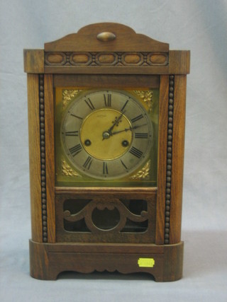An Edwardian bracket clock with brass dial and silver chapter ring contained in an oak case