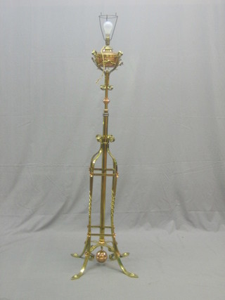 An Art Nouveau brass adjustable oil lamp with planished copper reservoir