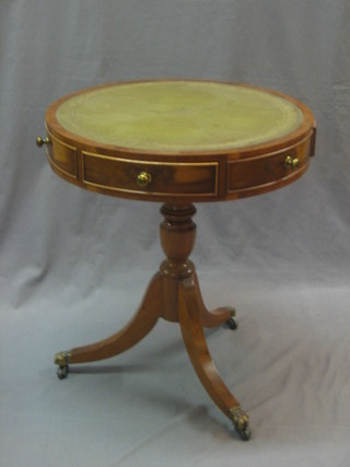 A Georgian style yew circular drum table with inset green leather writing surface, raised on pillar and tripod supports 21"