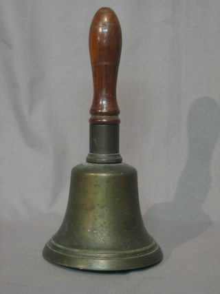 A large brass bell with turned wooden handle