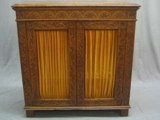 A Victorian carved oak chiffonier base enclosed by panelled doors, raised on a platform base 36"