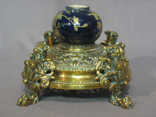 A handsome 19th Century pierced brass inkwell raised on 4 griffin supports with porcelain inkwell to the centre 6"