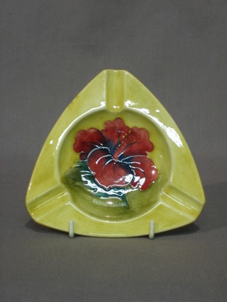 A Moorcroft Hibiscus pattern triangular shaped, yellow glazed ashtray, the base impressed Moorcroft K, 5"