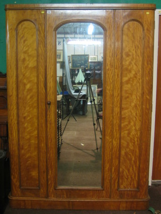 A Victorian bleached mahogany wardrobe enclosed by an arch plate mirror panelled door, raised on a platform base 56"