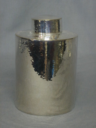 A cylindrical planished silver plated caddy