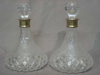 A pair of cut glass ships decanters with silver collars