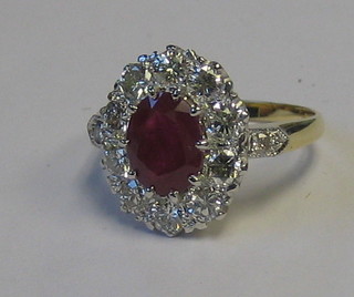 A lady's attractive 18ct gold dress ring set an oval cut ruby  surrounded by 10 diamonds and having 2 diamonds to the shoulders (approx 1.40/2.25ct)