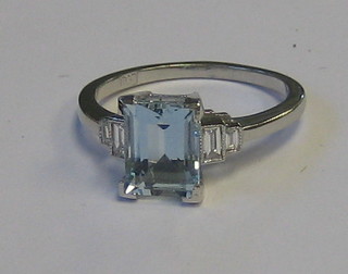 A lady's 18ct white gold dress ring set a rectangular cut aquamarine supported by 4 baguette cut diamonds