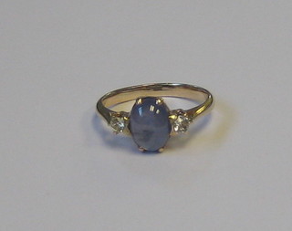 A gold ring set a cabouchon "sapphire" surmounted by 2 diamonds