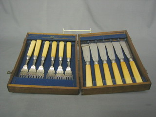A set of 6 silver plated fish knives and forks contained in a walnut canteen box