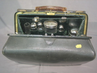 A leather Gladstone bag containing 5 cut glass bottles with silver plated mounts