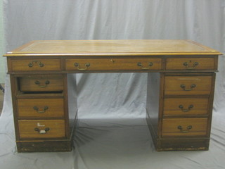 An Edwardian walnut kneehole pedestal desk with inset tooled writing surface above 1 long and 8 short drawers 60"