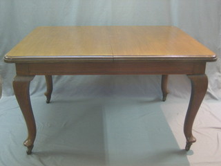 An Edwardian walnut rectangular extending dining table with 1 extra leaf, raised on cabriole supports 54"