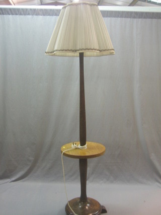 An Art Deco walnut reeded standard lamp, the base incorporating a table