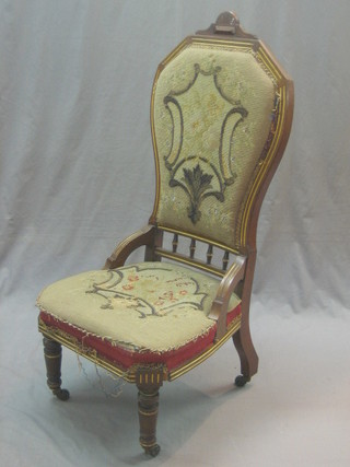 A Victorian carved walnut show frame nursing chair with upholstered seat and back raised on turned supports
