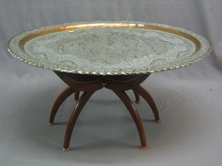 A large Eastern embossed metal tray complete with folding stand
