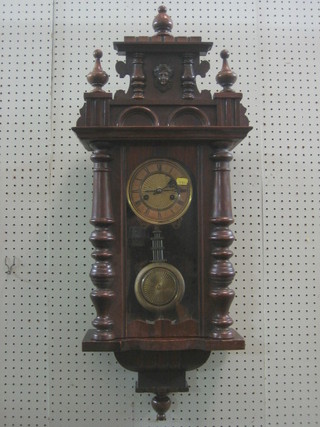 A striking Vienna regulator with paper dial and Roman numerals grid iron pendulum contained in a walnut case