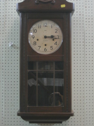 A chiming wall clock with  Arabic numerals contained in oak case
