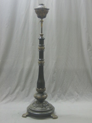 An adjustable 19th Century standard oil lamp reservoir with wooden reeded column and "Doulton" rings, raised on 3 bronzed panelled supports