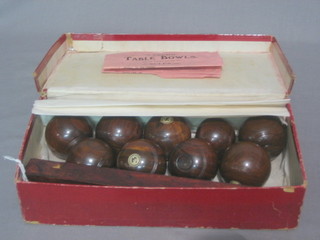 A set of 9 turned lignum vitae table bowls by Mancho, contained in a cardboard case