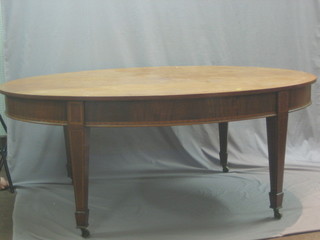 An Edwardian Georgian style oval dining table, raised on square supports ending in spade feet 71"