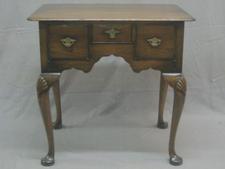 A 20th Century, 17th Century style oak low boy fitted 3 long drawers, raised on cabriole supports 31"