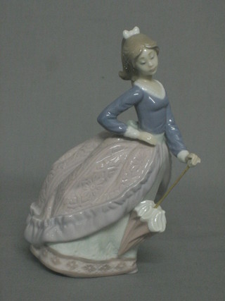 A Lladro figure of a promenading lady with parasol, the base impressed V-14JU 73 7"