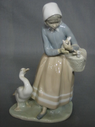 A Lladro figure of a standing lady with geese 9"