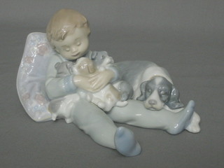 A Lladro figure of a reclining boy with dog and puppies, the base impressed 1535 7"