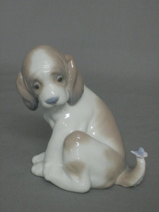 A Lladro 1984 figure of a seated puppy with butterfly on tail 4"