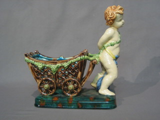 A Majolica table centre piece in the form of a cherub with cart 9"