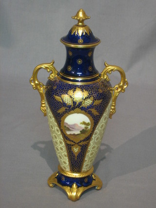 A Coalport porcelain twin handled urn and cover with garter blue and gilt banding, the centre with panel decoration depicting a mountain (foot and lid f and r) 9"