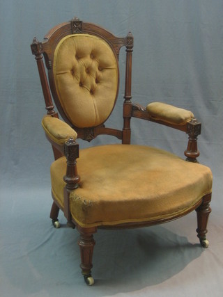 A late Victorian carved mahogany open arm chair raised on turned supports upholstered in orange material